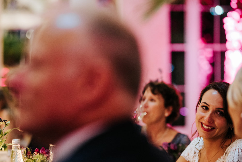 Bride looks at her mum and smiles during her husband's wedding speech