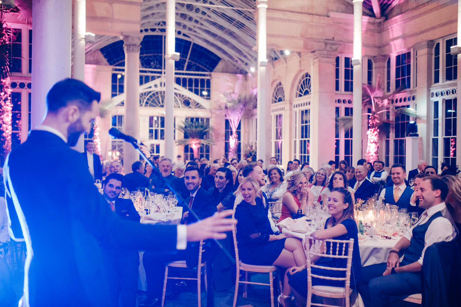 Groomsman delivers his speech while the audience is in tears of laughter