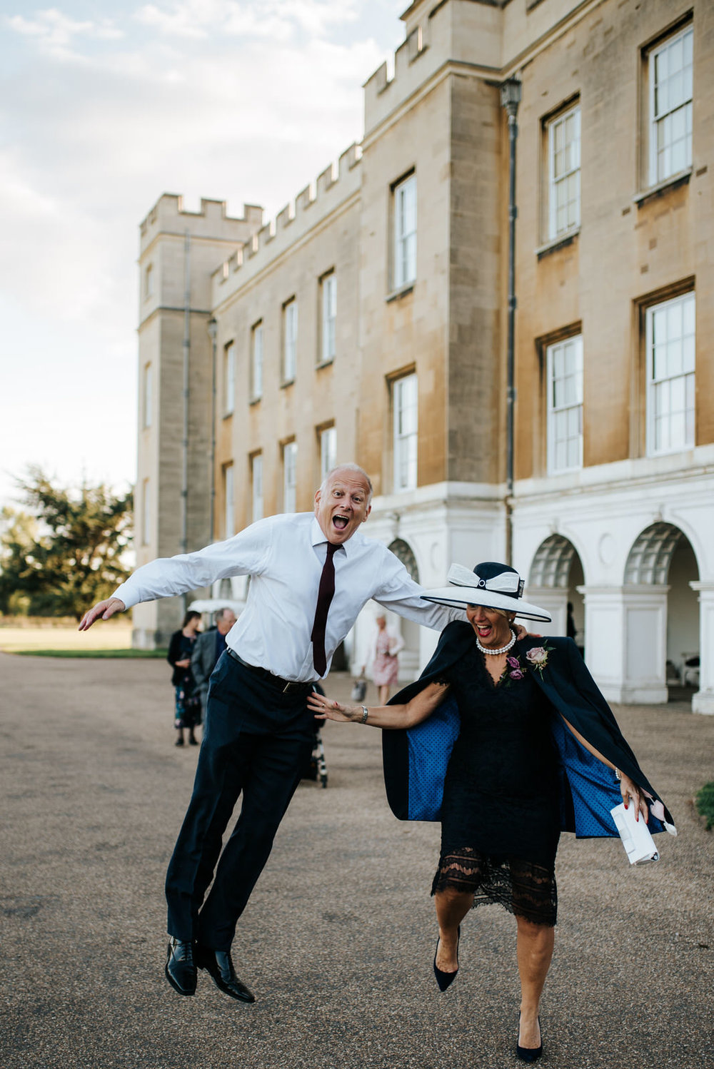 Bride's step-dad and mum jump with joy as they walk towards Syon Park Grand Conservatory