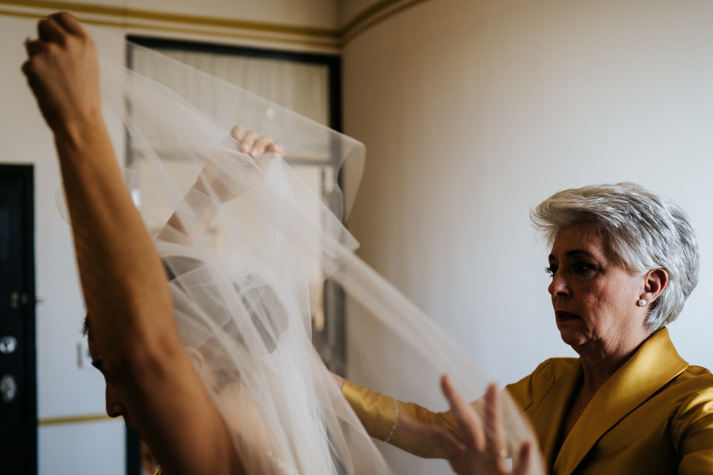  Bride's mother helps her put on the veil before the ceremony 