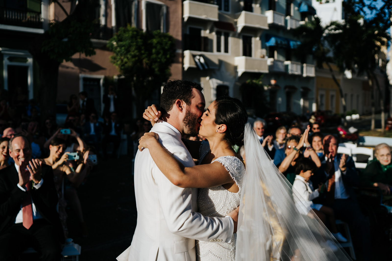 Bride and groom exchange their first kiss as husband and wife during their wedding ceremon with beautiful sunshine weather