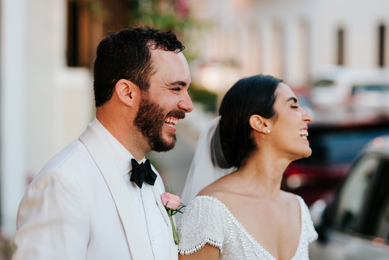 Bride and groom smile at group of students that are looking at them from across the street