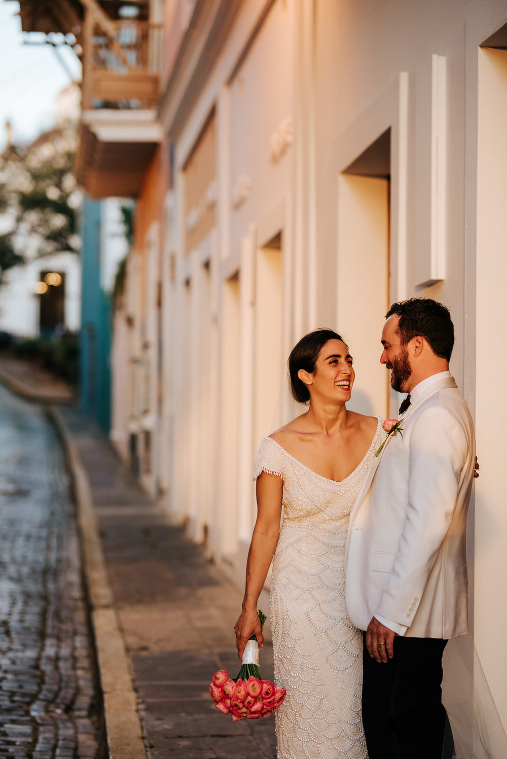  Beautiful, warm light shines on bride and groom as the sun sets in front of them and they embrace in the streets of Old San Juan 