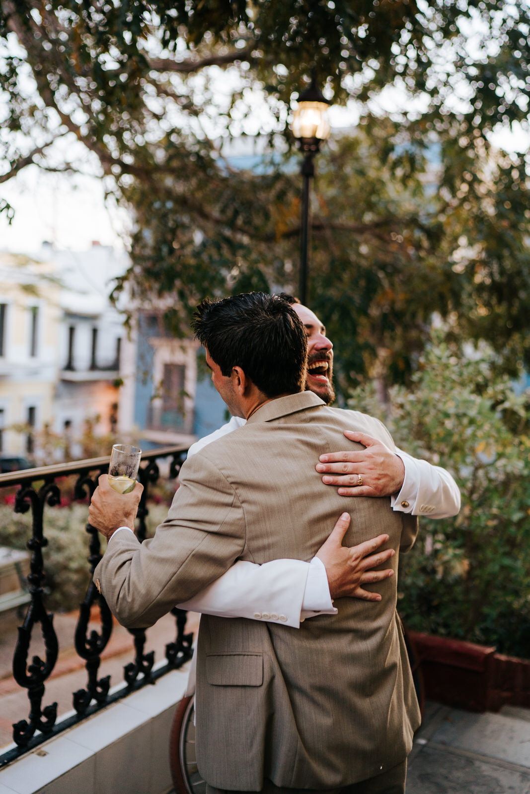 Groom has an outburst of joy and hugs a friend as he returns to the hotel El Covento for the wedding reception