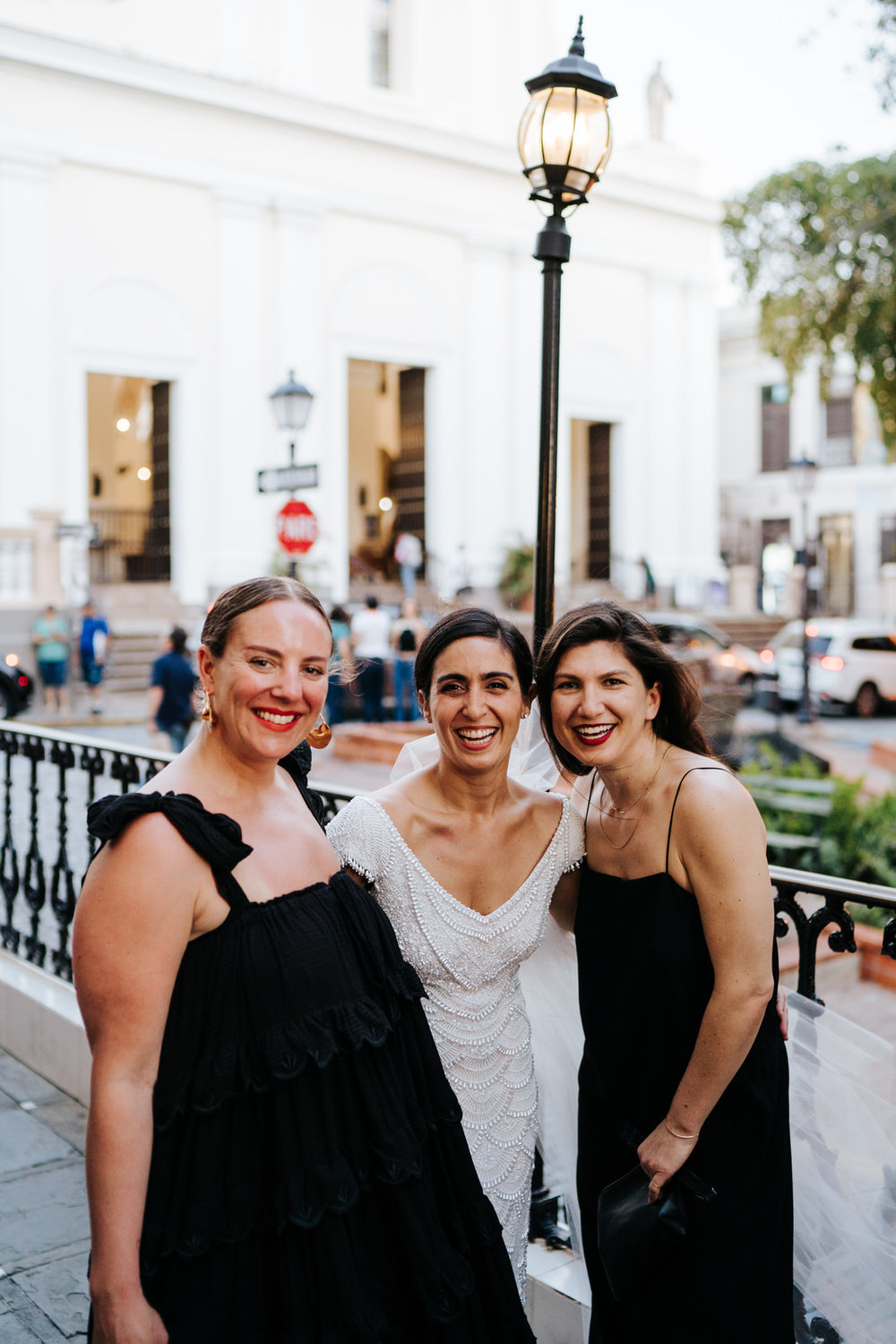  Group photograph of bride and two of her friends posing for a photo and looking at the camera 