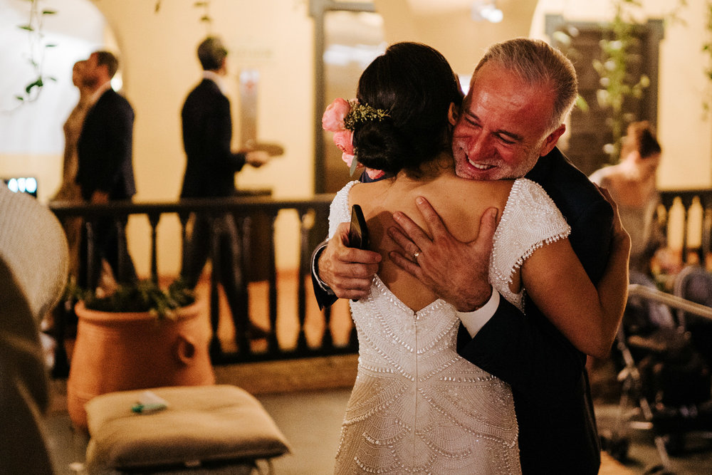  Bride embraces a family member during the cocktail hour at the wedding 