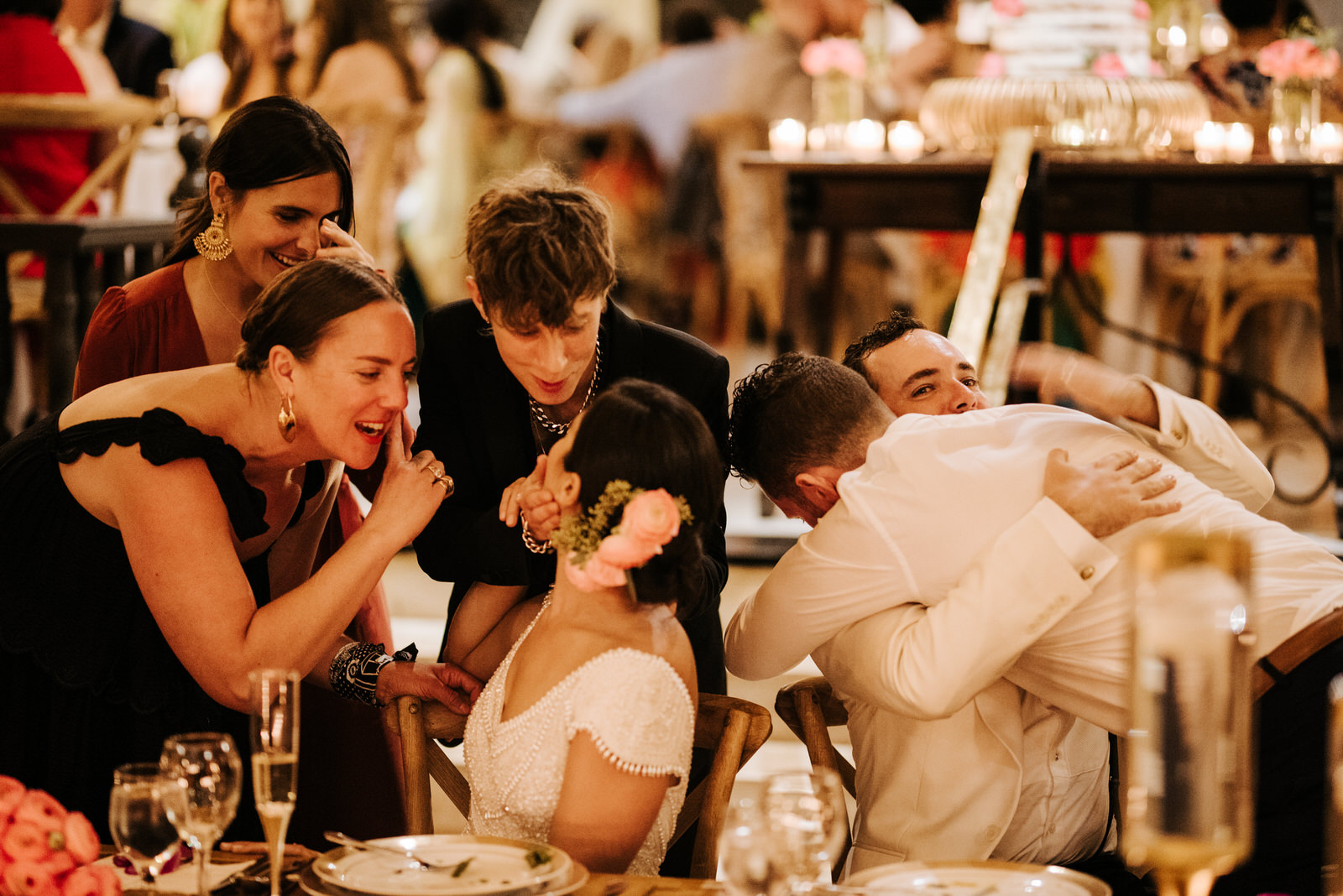 Friends of the bride and groom crowd their table as they all talk and laugh