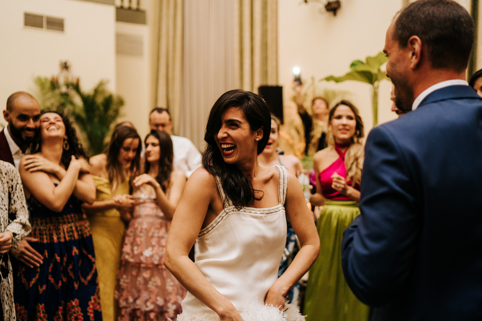 Bride smiles and cheers as she dances on the dancefloor