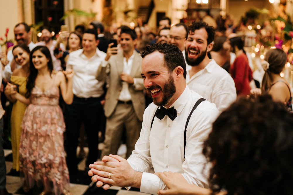  Groom laughs and claps his hands as he reacts to the friend who took the microphone 