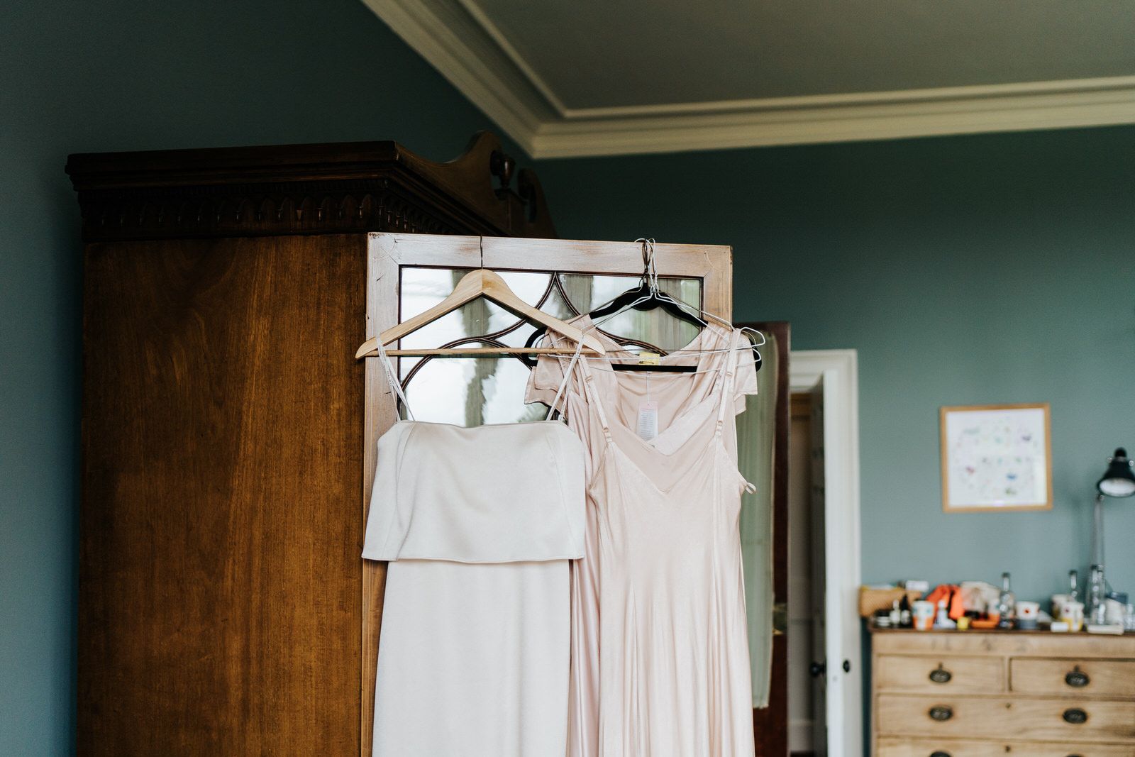  Bridesmaid dresses hang on the door of a closet in dressing room 