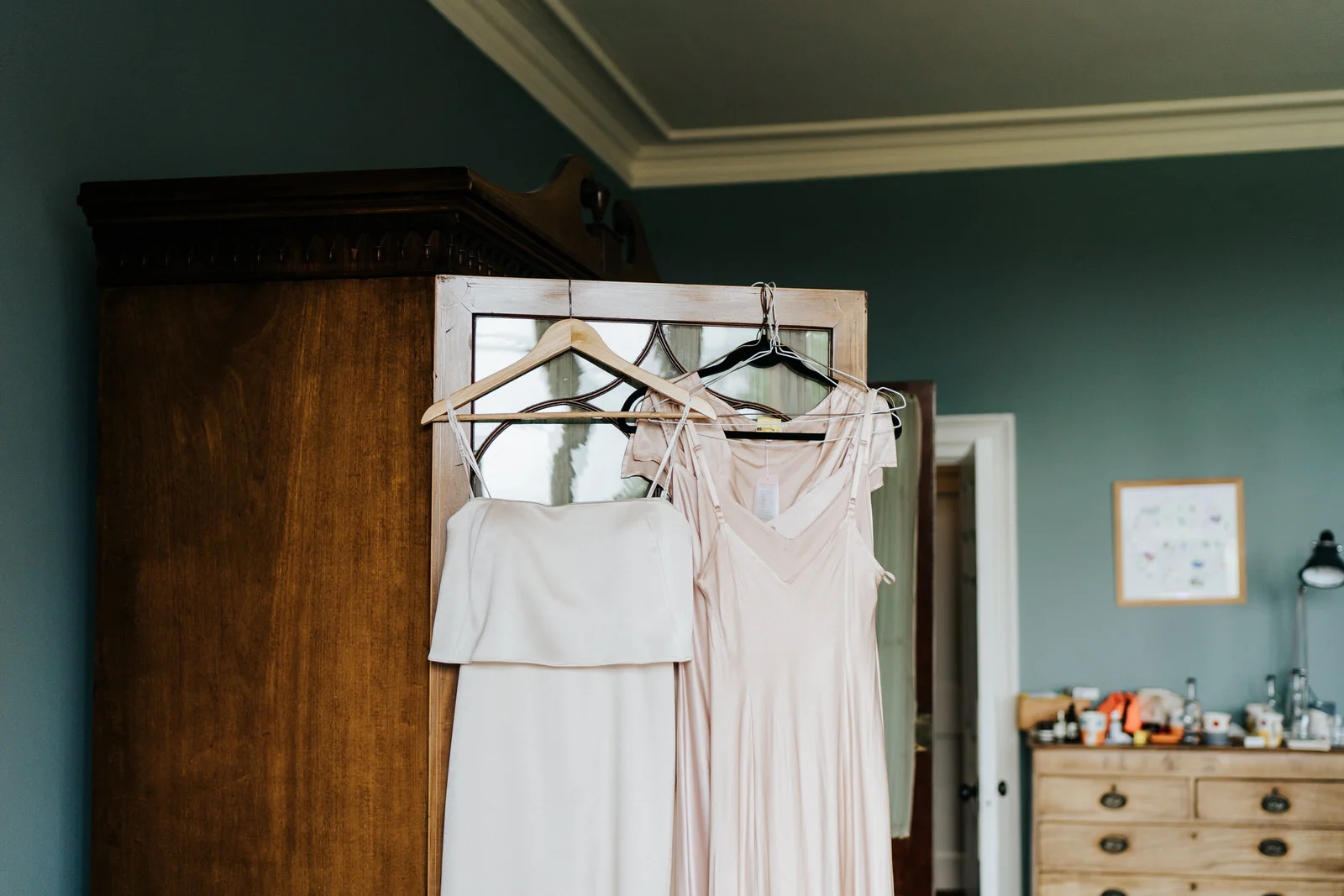 Bridesmaid dresses hang on the door of a closet in dressing room