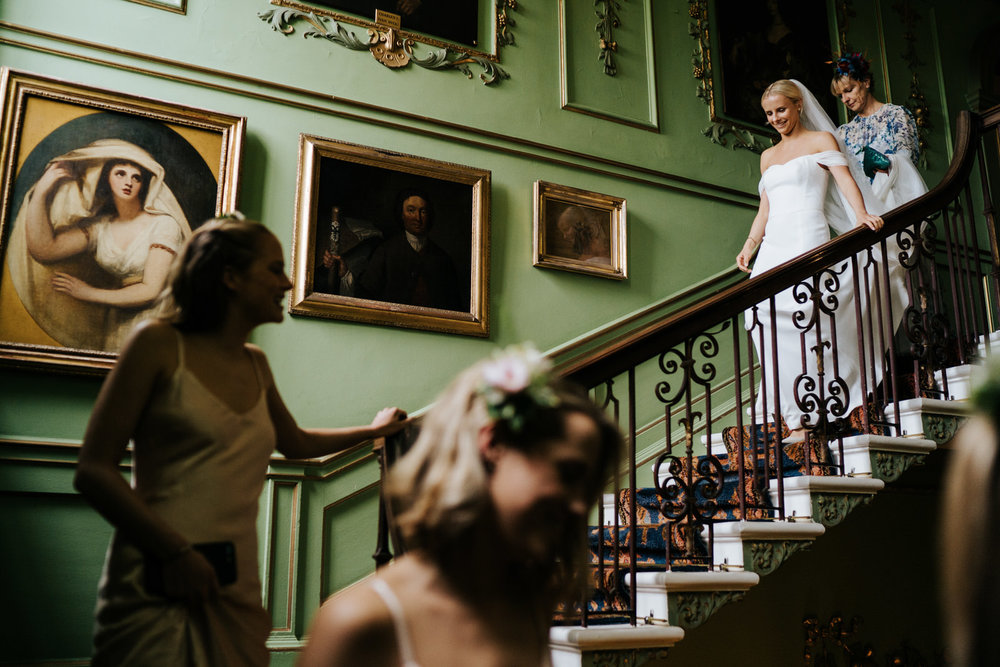  bride, two sisters and mother of the bride walk down the stairs at Hawarden Castle Wedding 