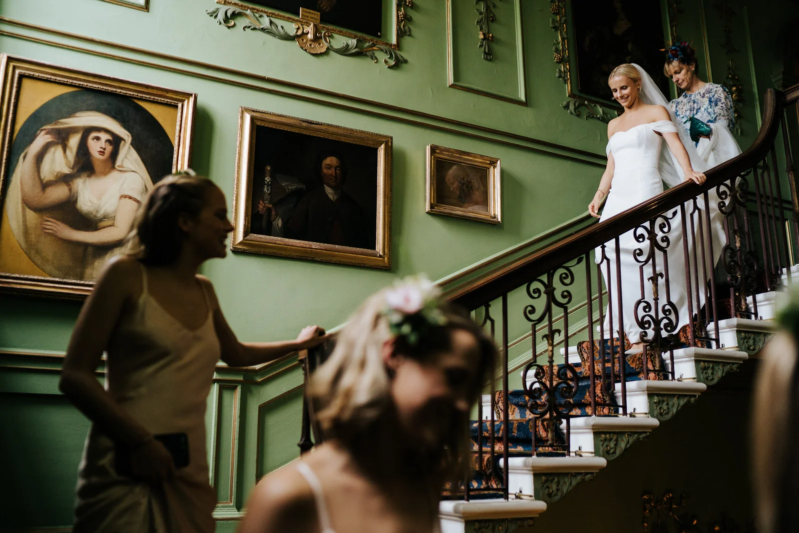 bride, two sisters and mother of the bride walk down the stairs at Hawarden Castle Wedding