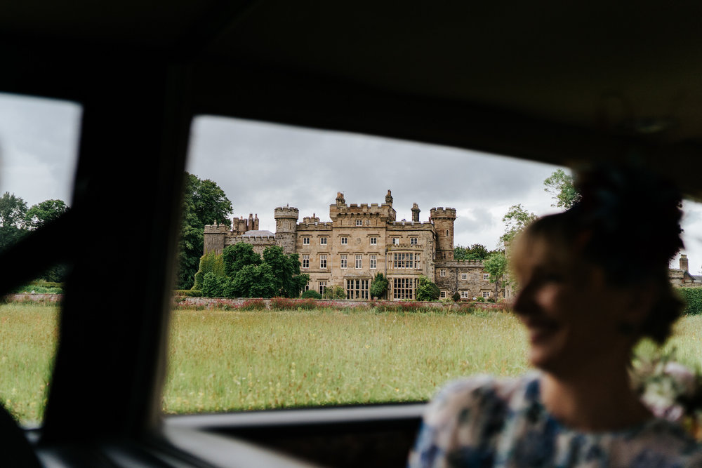  Wide photograph of Hawarden Castle Wedding Venue from the car that is driving to venue 