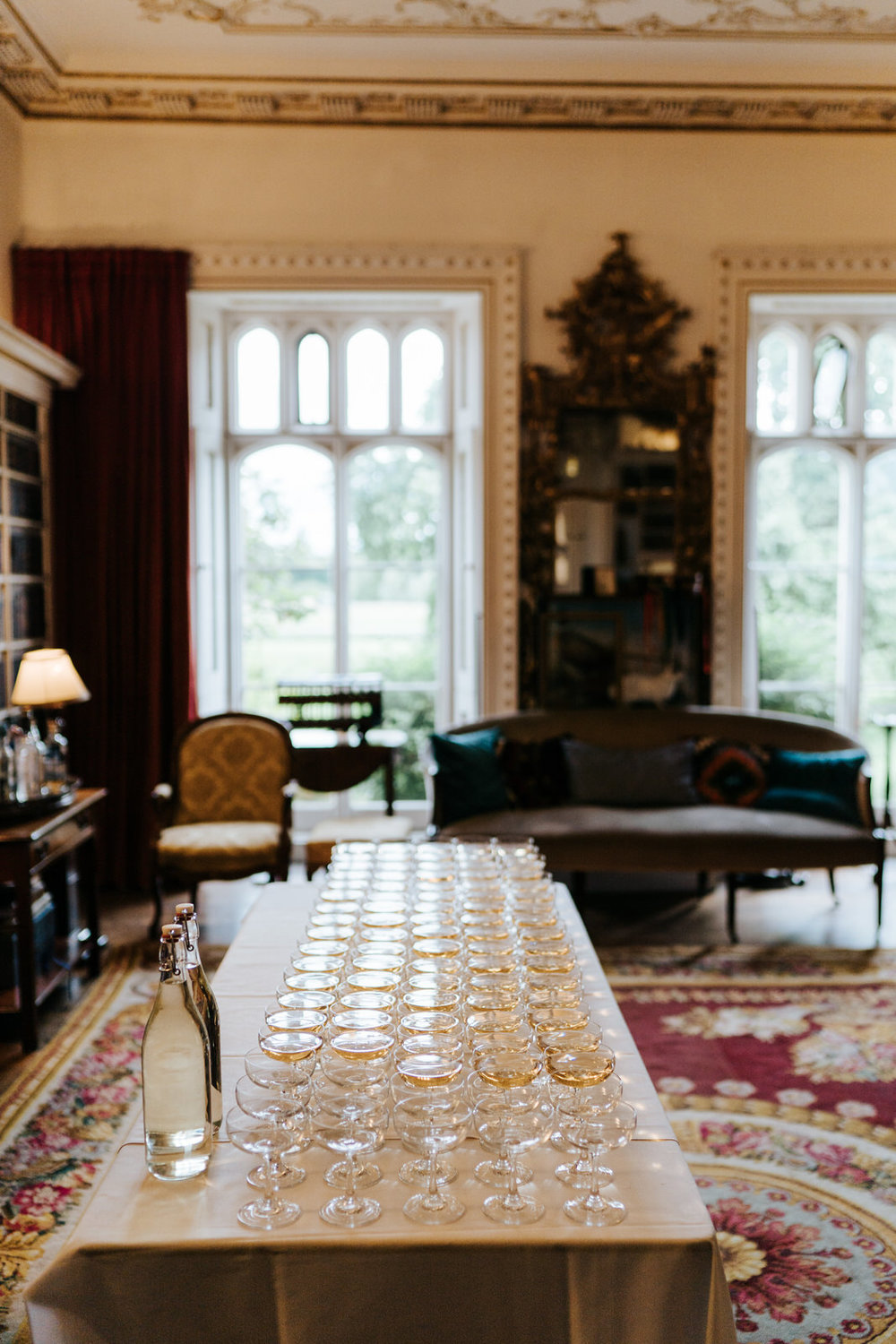  Wide photograph of the inside of Hawarden Castle focusing on a table filled with glasses and champagne 