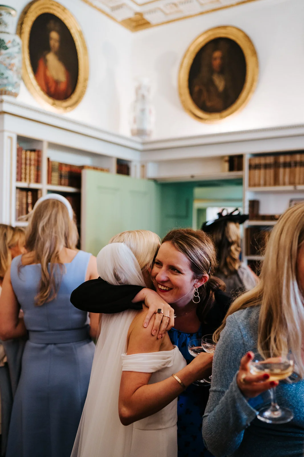 Bride hugs a friend during the champagne reception in historic Hawarden Castle