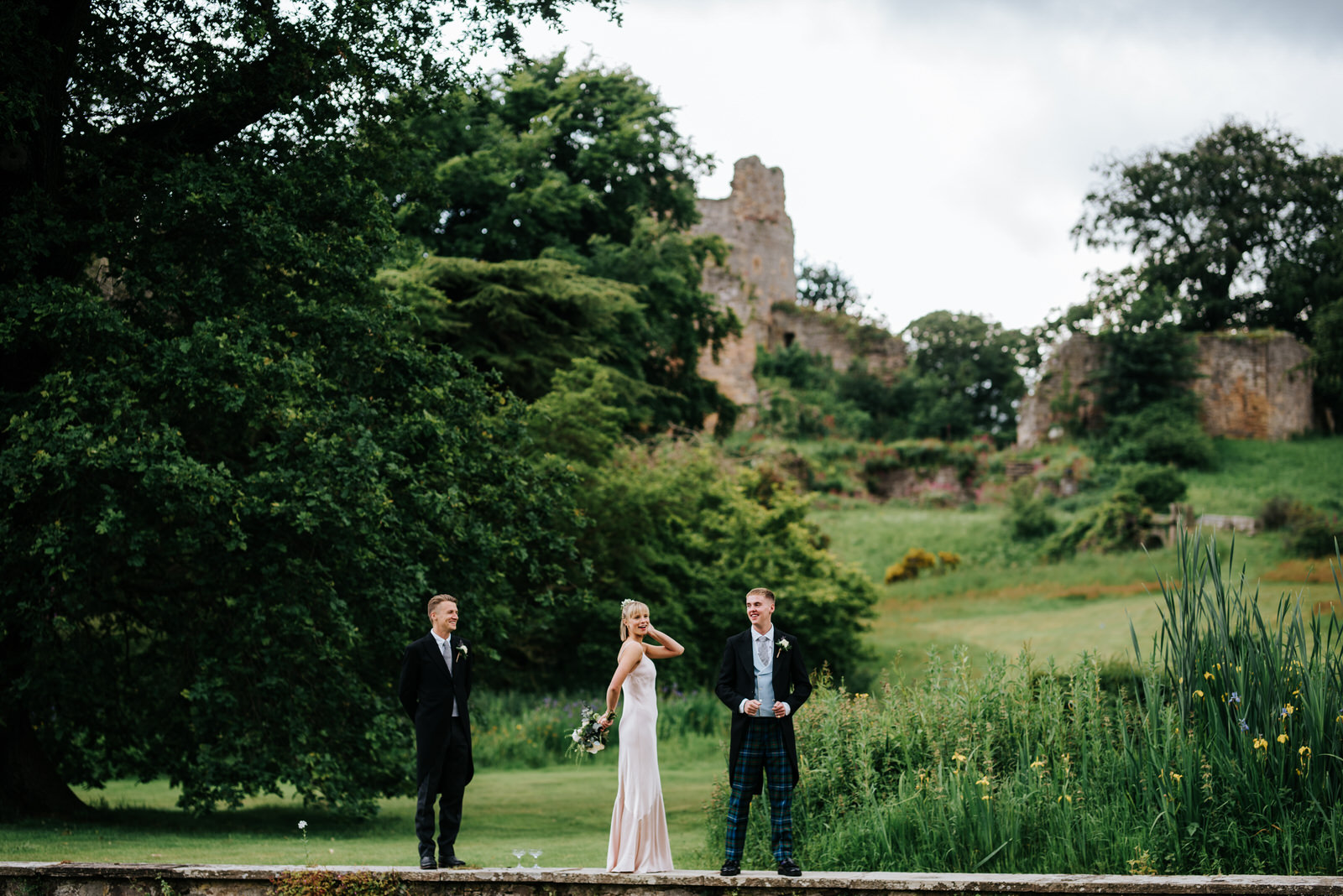  Bride's three siblings goof around outside Hawarden Castle 