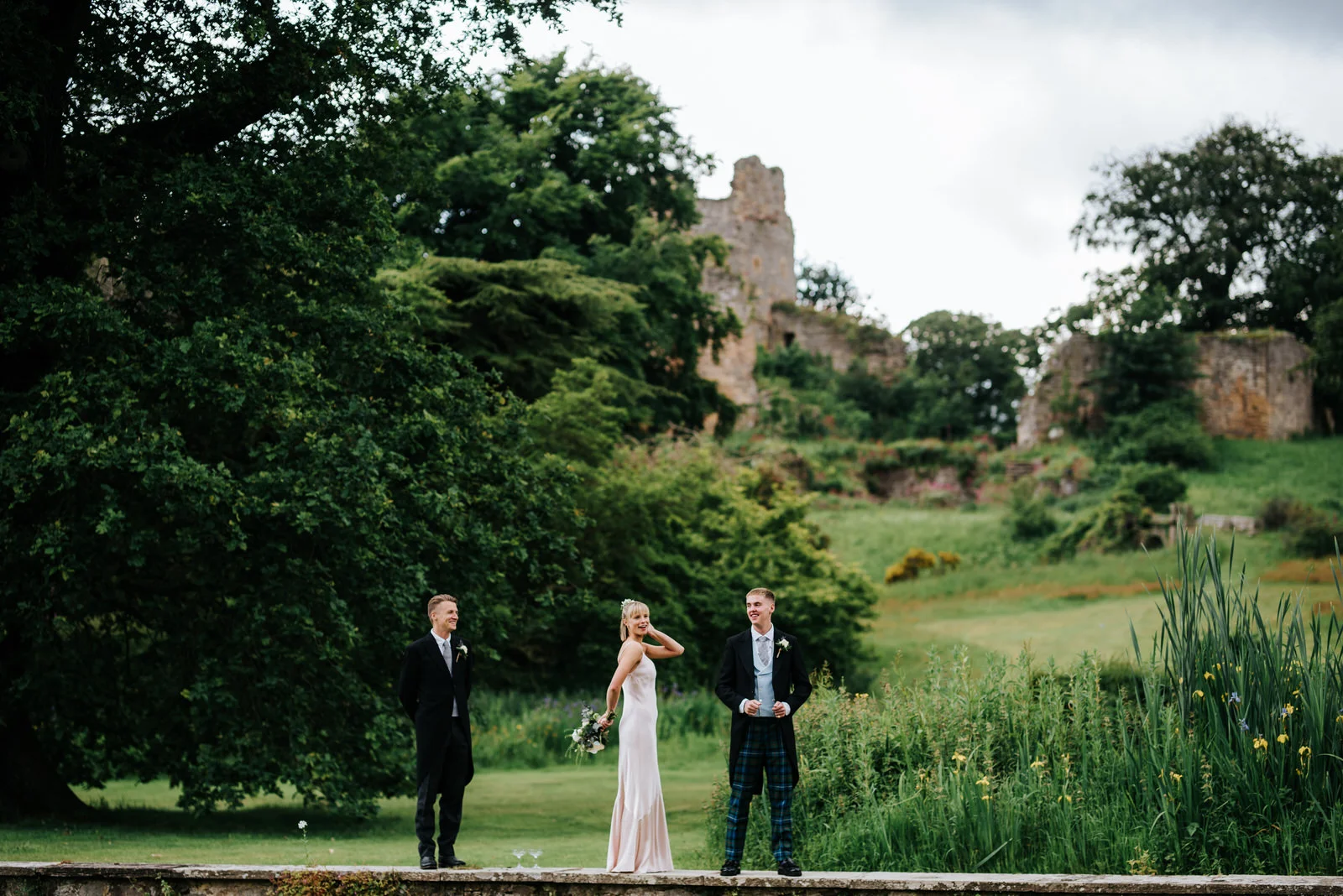 Bride's three siblings goof around outside Hawarden Castle