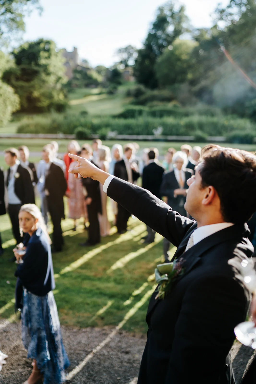 Master of ceremony points towards marquee and instructs guests to make their way towards it