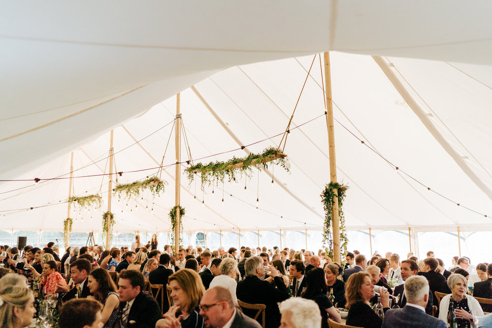  Wide photograph of the entire marquee and all the guests chatting and drinking 