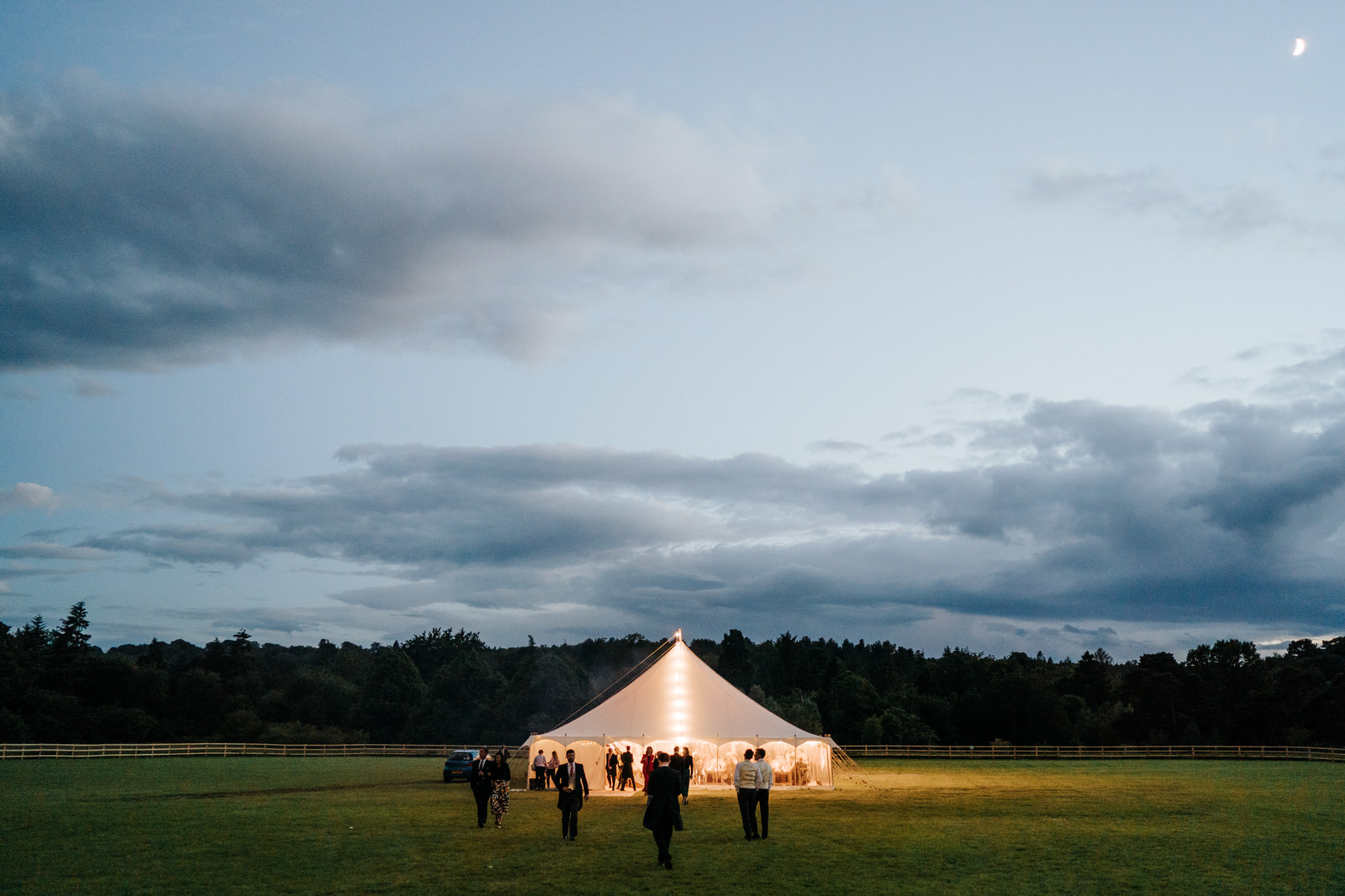 Wide photograph of the marquee during dusk as the moon illuminates the sky at Hawarden Castle in Wales
