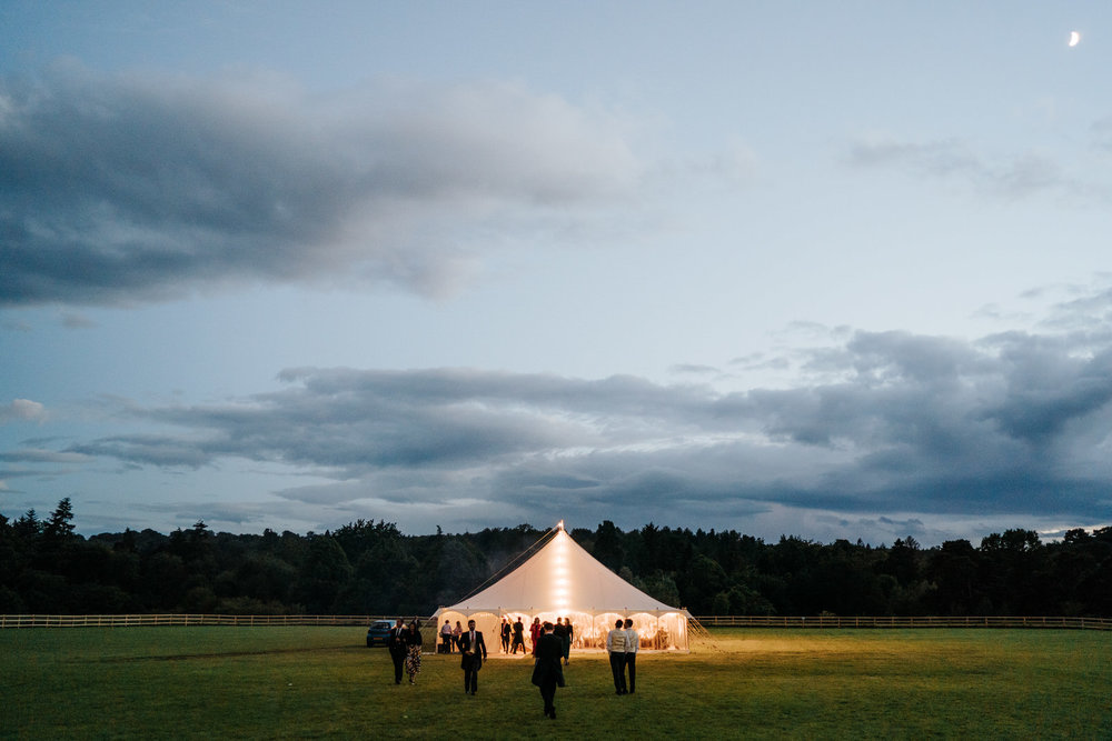  Wide photograph of the marquee during dusk as the moon illuminates the sky at Hawarden Castle in Wales 
