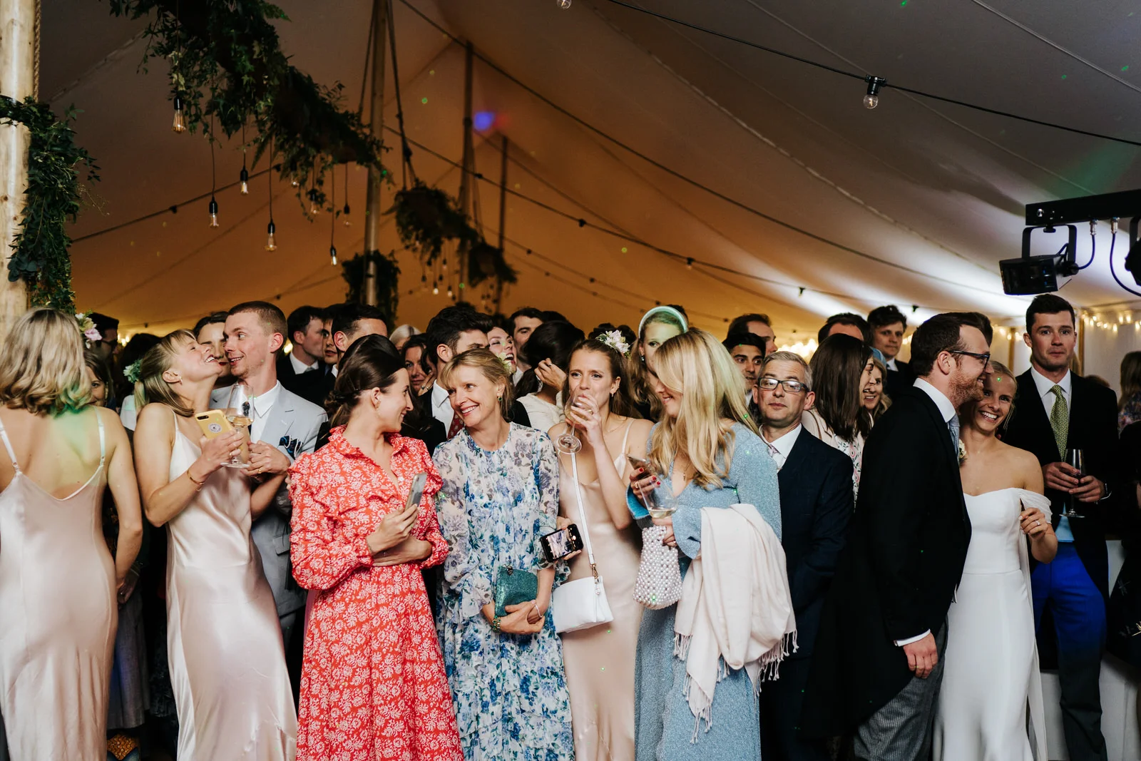 Commotion of guests near the dancefloor as bride and groom prepare for their first dance