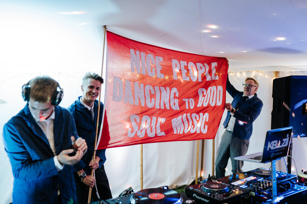  DJs waving big red flag that reads nice people dancing to good soul music 