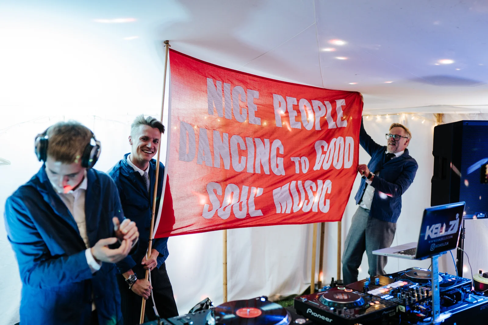 DJs waving big red flag that reads nice people dancing to good soul music