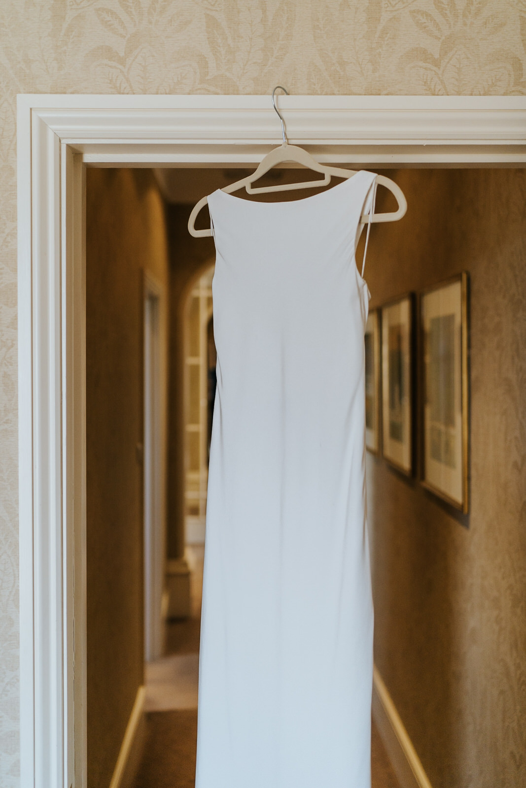  Beautiful white wedding dress hanging from door at The Petersham Hotel in Richmond 