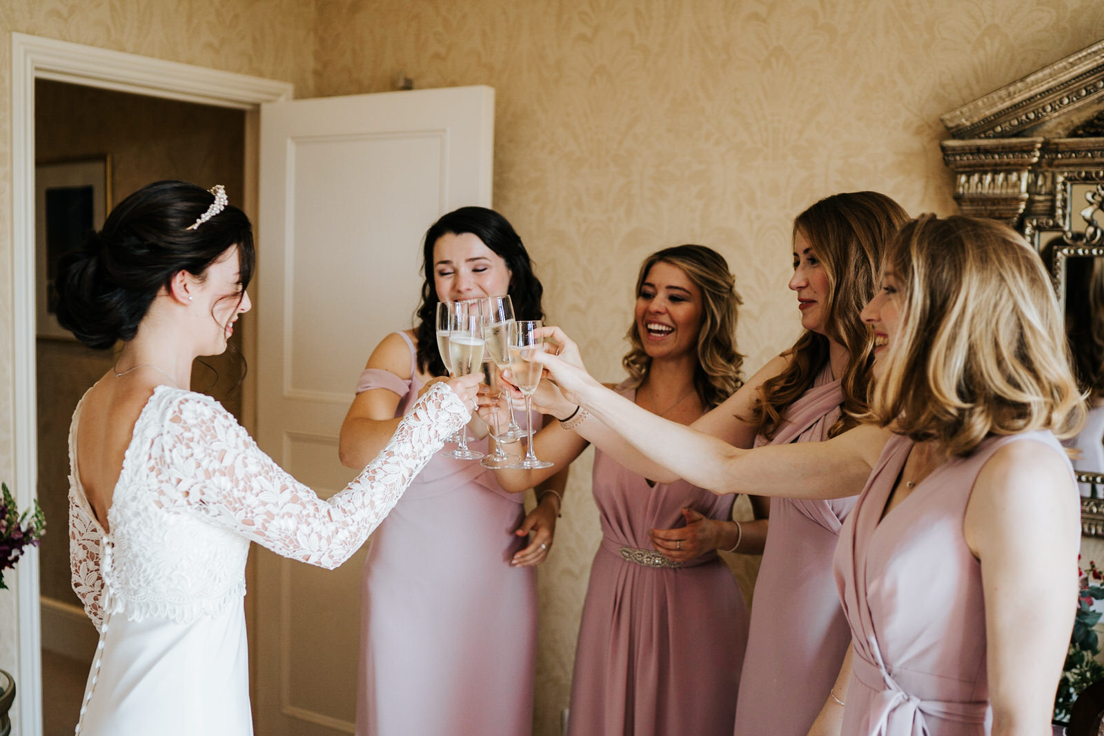  Bride and bridesmaids clinck glasses and cheer 