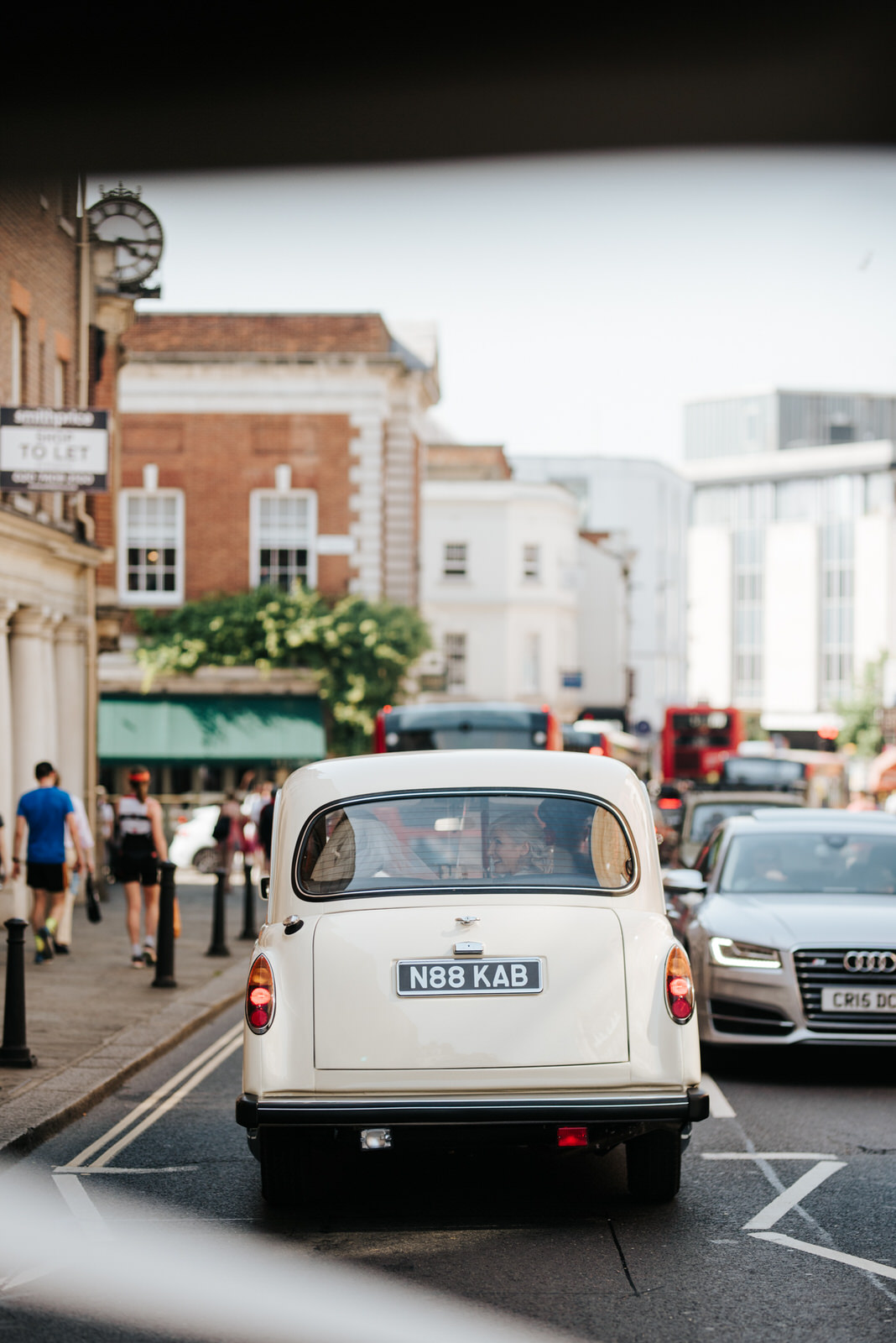  Wide photograph of the bridal car driving through Richmond towards Kew Gardens for the wedding ceremony 