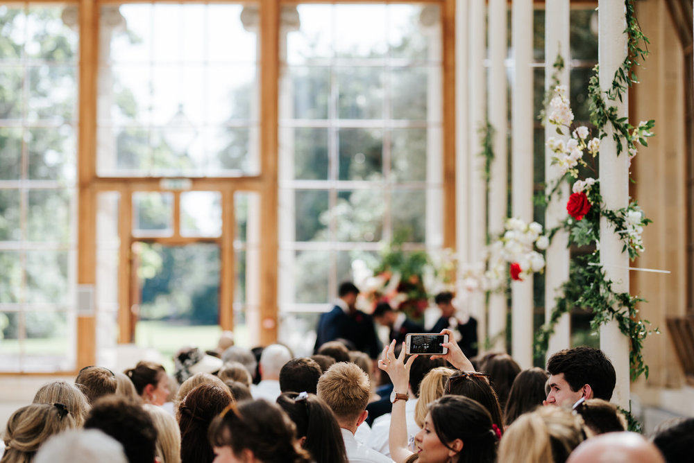 Guest takes a photograph of the beautiful wedding venue at Kew Gardens in London 