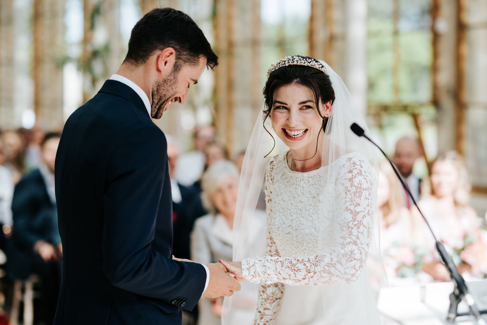  Groom puts ring on bride who cannot contain her excitement 