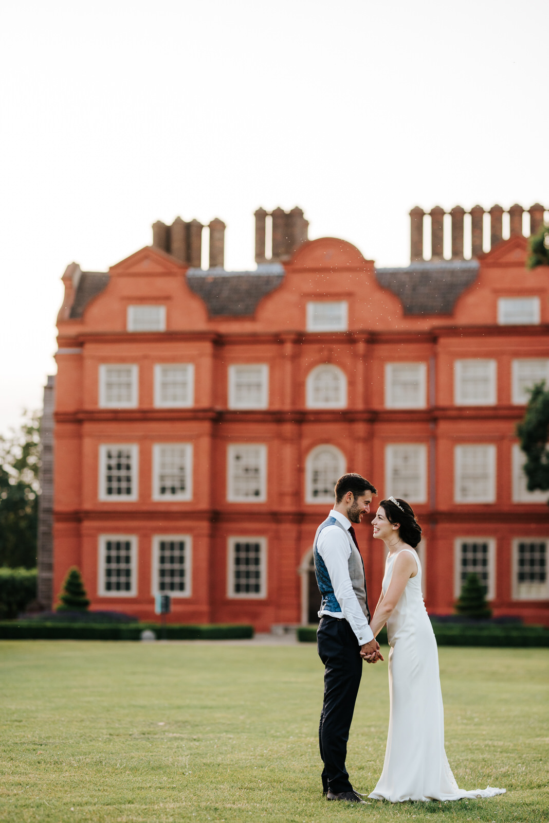  Bride and groom pose in front of kew palace in golden evening light at kew gardens wedding 