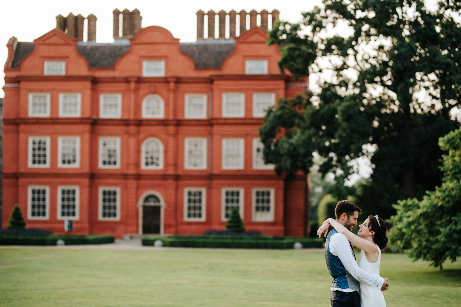  Bride and groom pose in front of kew palace in golden evening light at kew gardens wedding 
