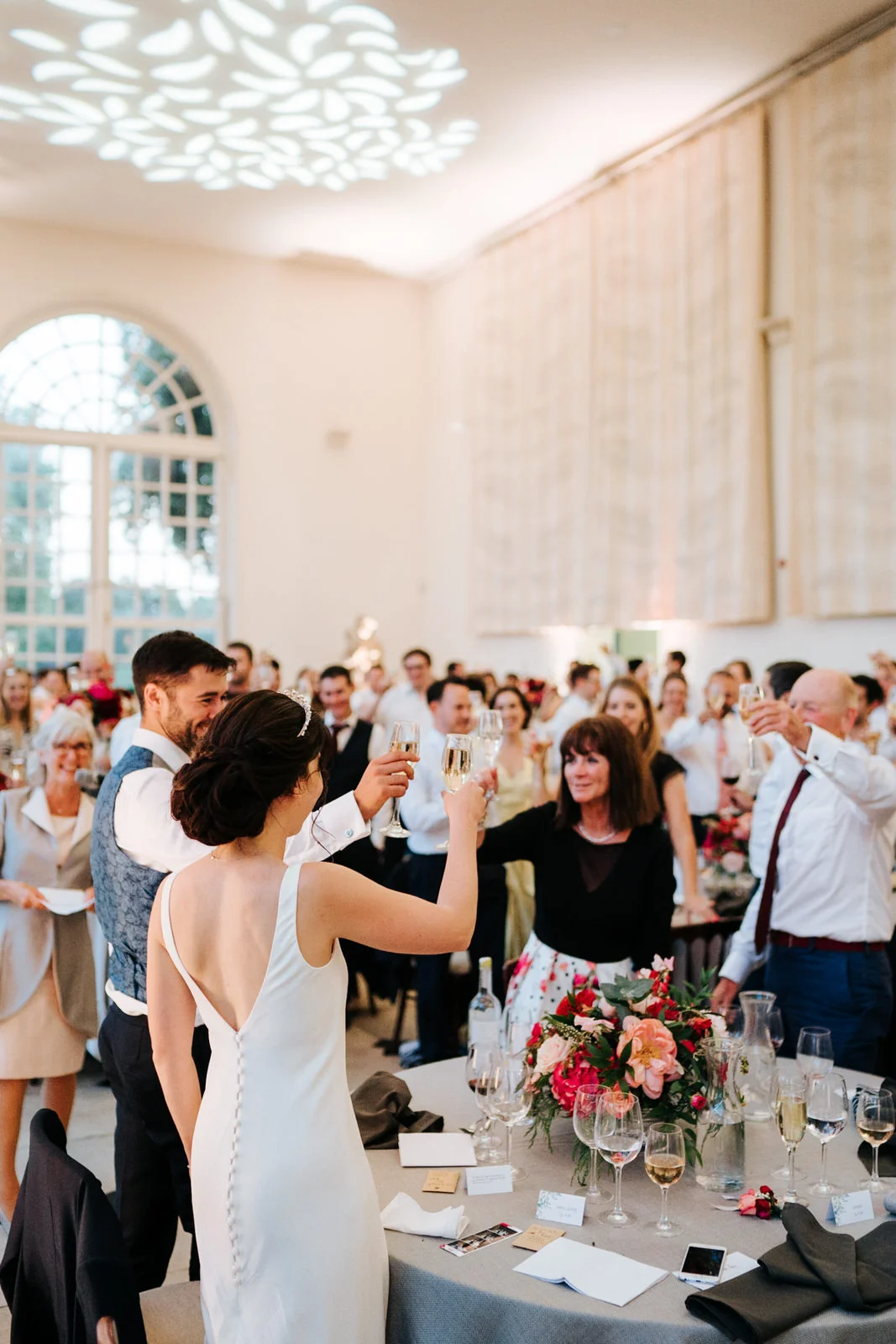 Bride and groom make a toast with all their guests as speech ends