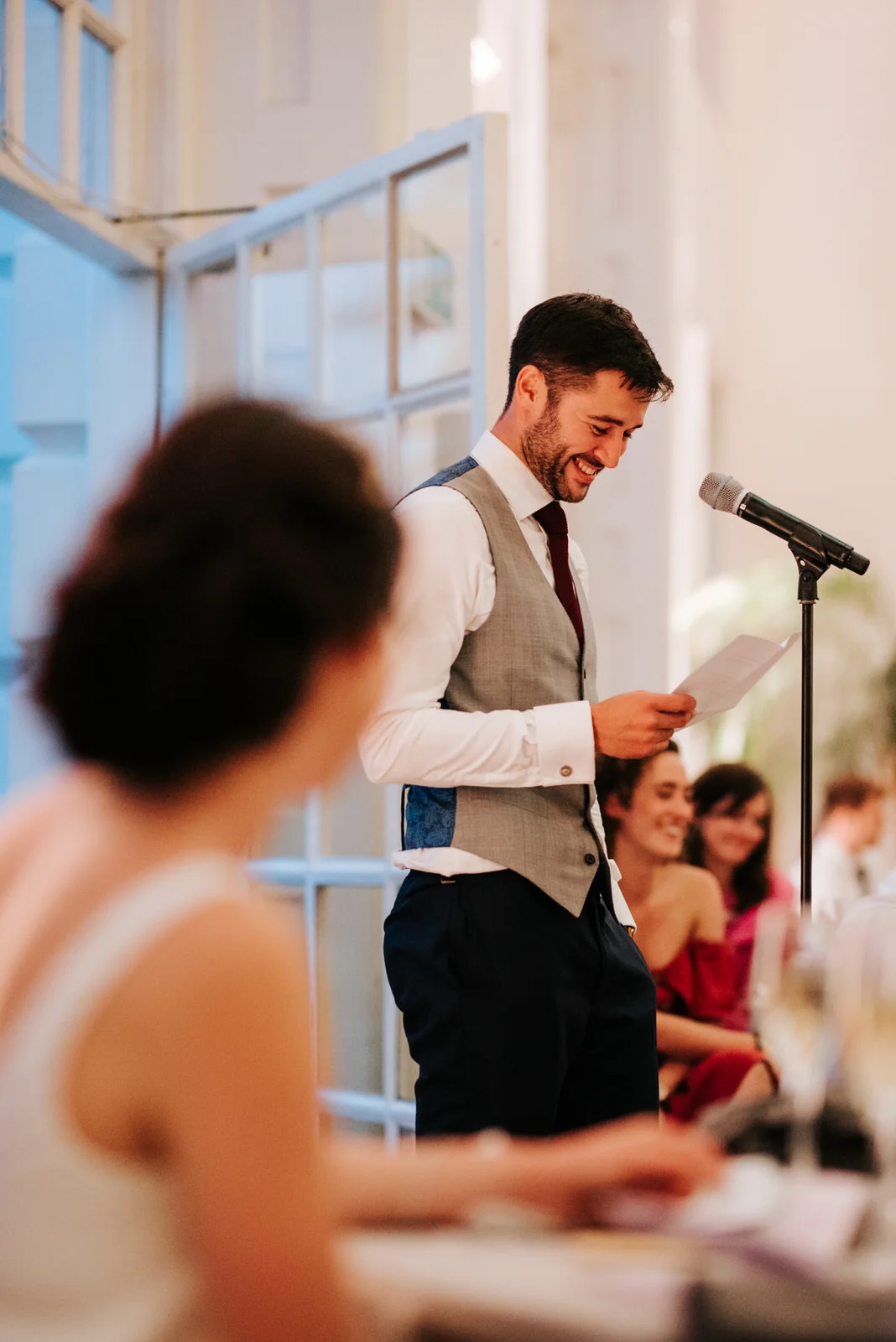 Groom smiles as he delivers his wedding speech