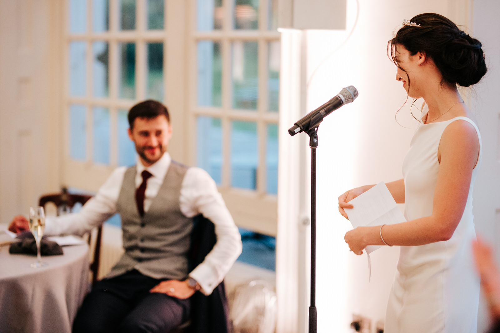  Bride finishes her speech and looks emotionally at groom 