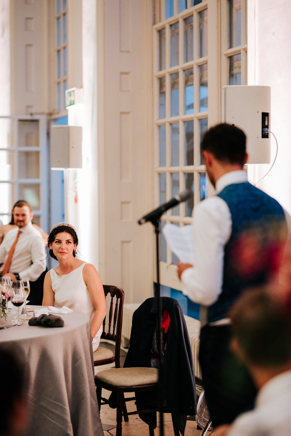  Bride looks emotionally at groom as he finishes delivering his wedding speech 