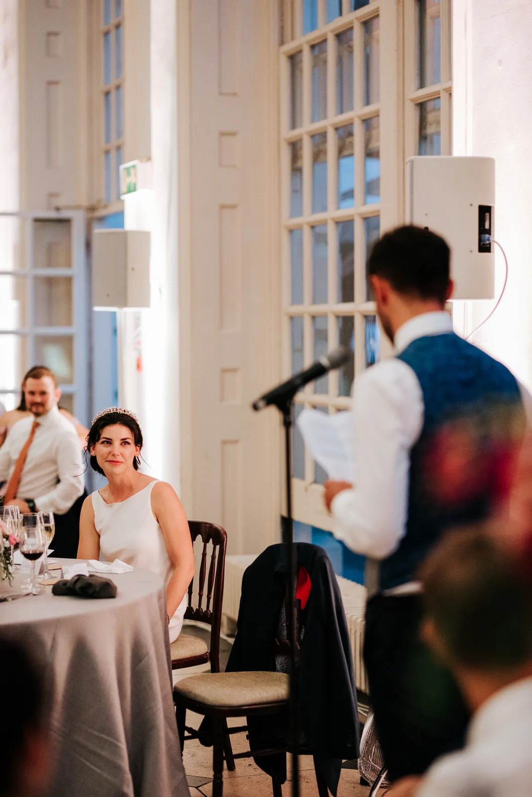 Bride looks emotionally at groom as he finishes delivering his wedding speech