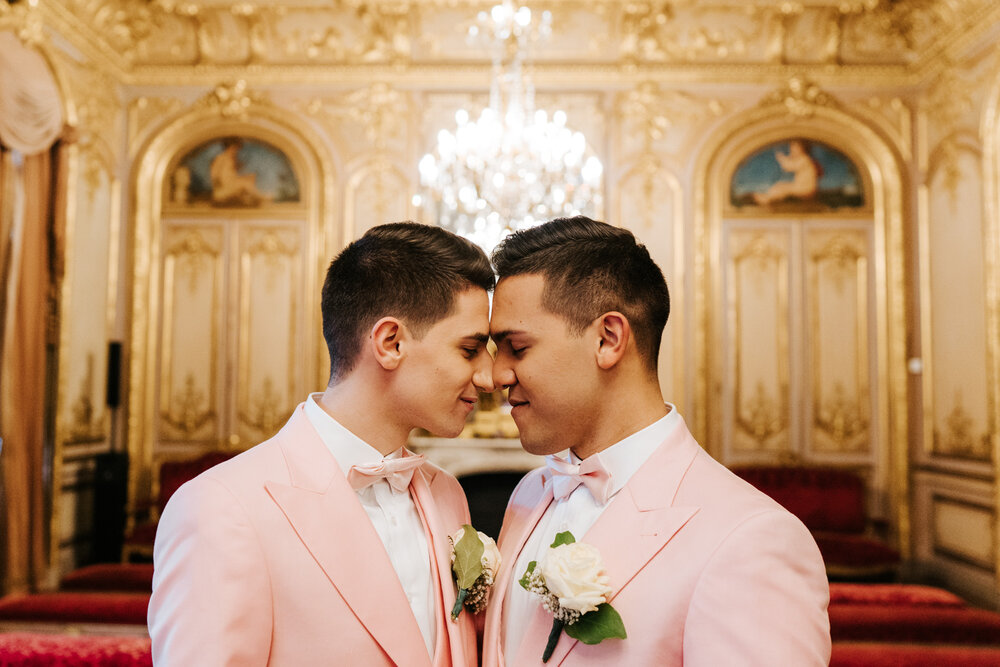  Both grooms touching foreheads in beautiful golden and grand room in Paris 