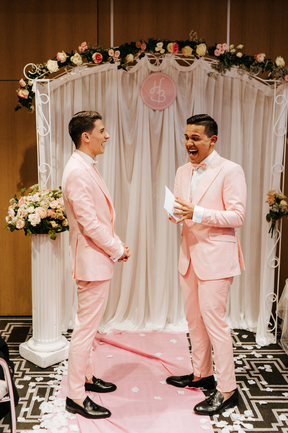  One of the grooms is about to start reading  his vows but cannot contain his laughter and excitement during same sex ceremony in Paris 
