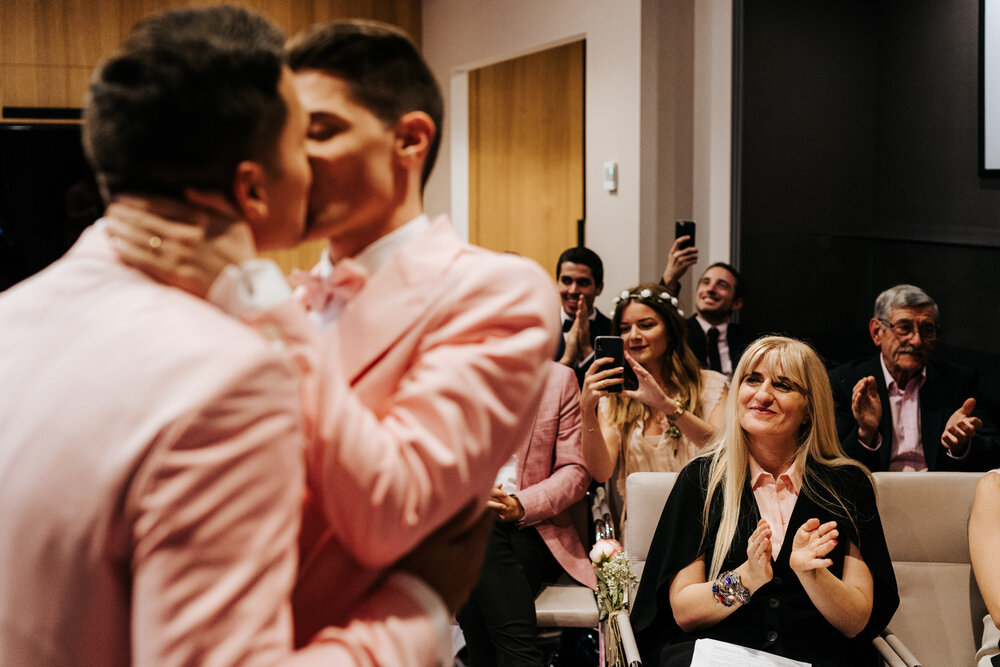 Guests and family clap and cheer as grooms have their first kiss during Paris same sex ceremony 
