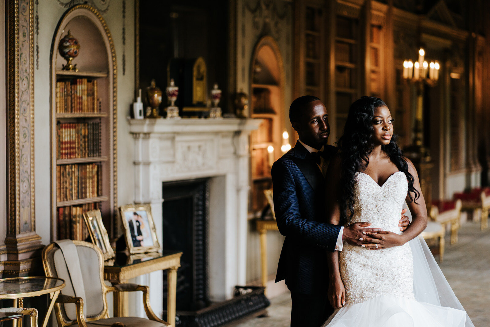 Bride and groom look out of the window at Syon Park House in regal wedding portrait 