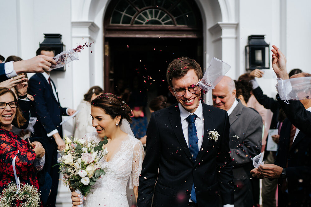 Bride and groom pelted with bag of confetti as they come out of St. Margarets Church in Hampstead, London
