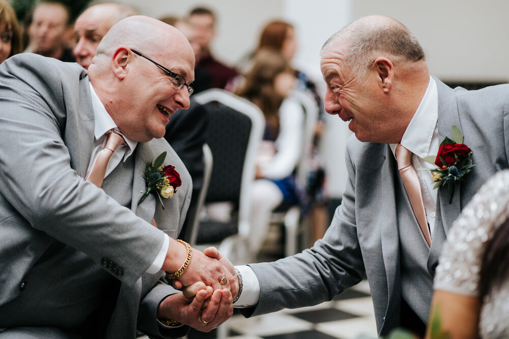 Father of the bride and father of the groom shake hands after wedding ceremony at York House in Twickenham