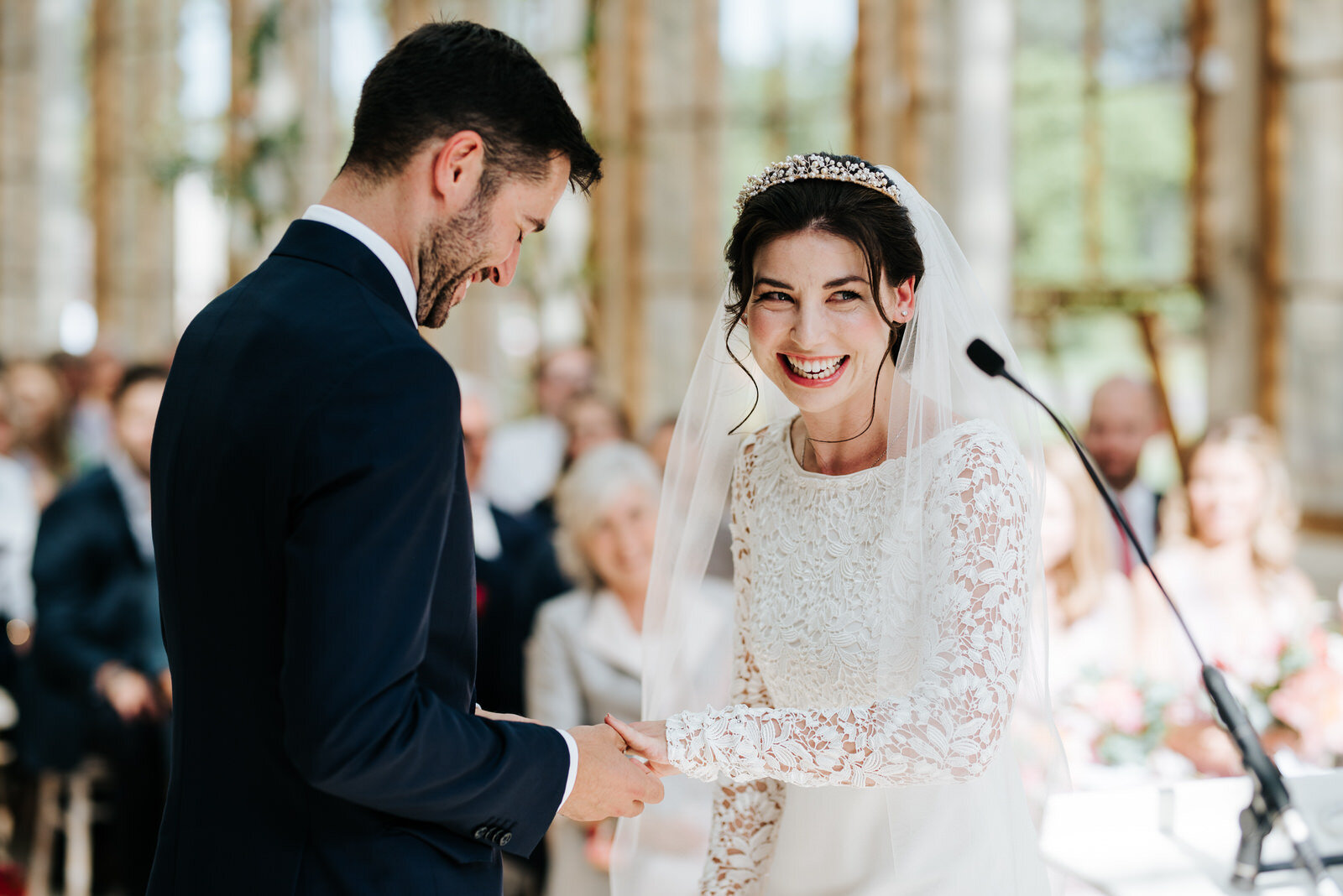 Bride is very excited as groom puts ring on her at Nash Conservatory wedding ceremony in Kew Gardens