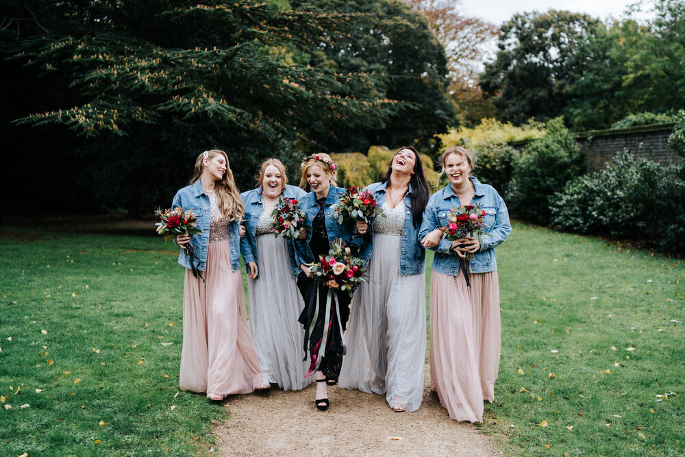 Bride and her bridesmaids talk to each other and walk towards camera 