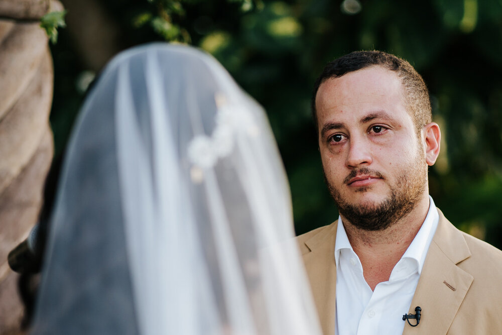 Groom's tears are rolling down his face during outdoor wedding ceremony 